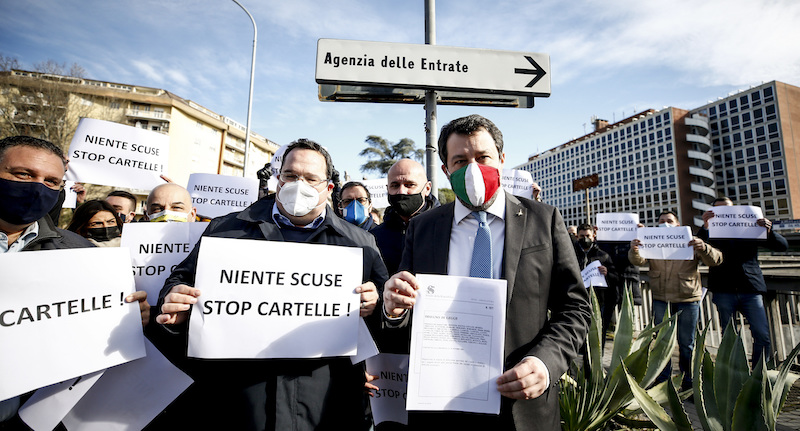 Matteo Salvini protesta davanti all’Agenzia delle Entrate a Roma nel 2020, tenendo in mano il progetto di legge sulla flat tax (Foto Cecilia Fabiano/LaPresse) 