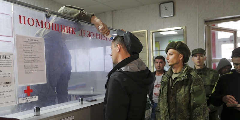 Un addetto misura la febbre ad alcuni riservisti in un centro di reclutamento di Volgograd, sabato 24 settembre (AP Photo)