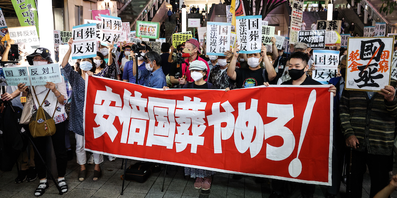 Una protesta contro i funerali di stato organizzati per Shinzo Abe fuori dalla stazione di Shinjuku, a Tokyo, il 25 settembre 2022 (Takashi Aoyama/Getty Images)