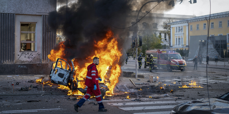 Un operatore medico cammina di fianco a un'auto in fiamme dopo il bombardamento a Kiev (AP Photo/Roman Hrytsyna)