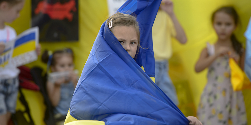 Una bambina ucraina scappata in Romania avvolta in una bandiera del suo paese (AP Photo/ Alexandru Dobre)