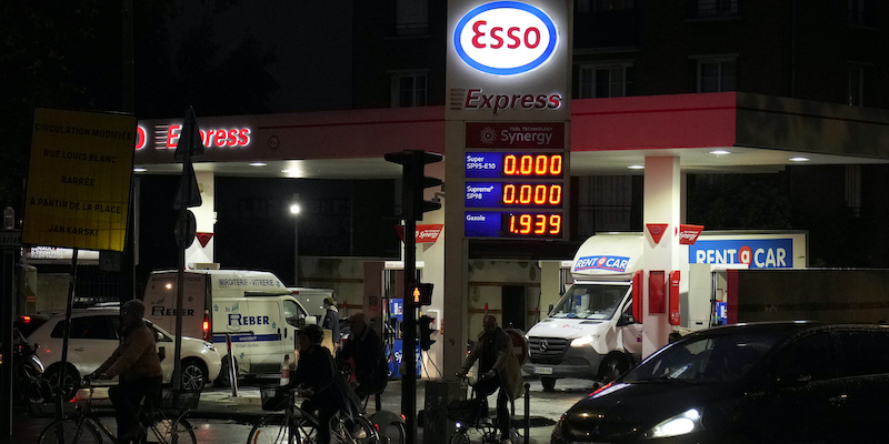 Una pompa di benzina a Parigi a cui è rimasto solo il diesel, e diverse persone che scelgono di muoversi in bici (AP Photo/Francois Mori)