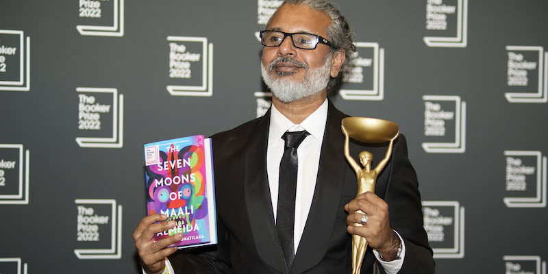 Lo scrittore srilankese Shehan Karunatilaka con il trofeo del Booker Prize e il suo romanzo "The Seven Moons of Maali Almeida", il 17 ottobre 2022, a Londra (AP Photo/Alberto Pezzali, LaPresse)