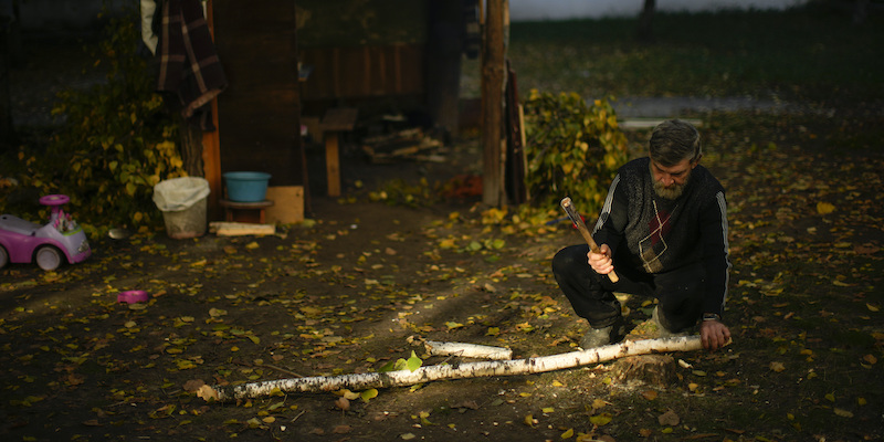 Un uomo taglia pezzi di legna da ardere a Kivsharivka, in Ucraina, il 16 ottobre (AP Photo/Francisco Seco)