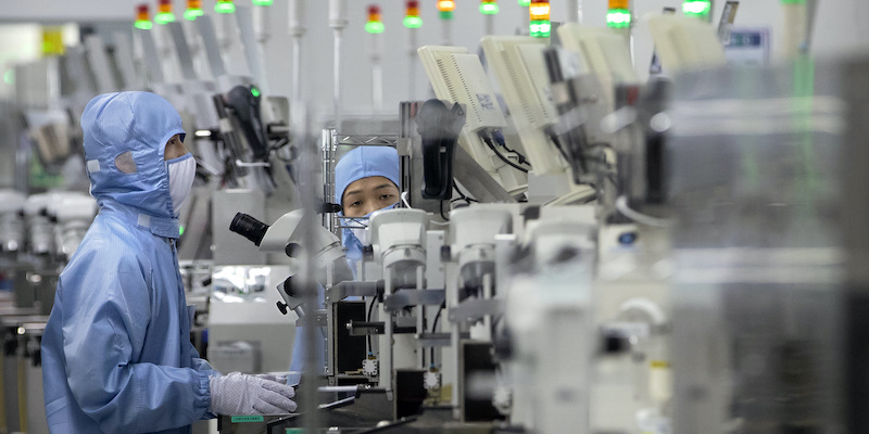 Dipendenti al lavoro in un'azienda cinese di semiconduttori (AP Photo/Mark Schiefelbein)