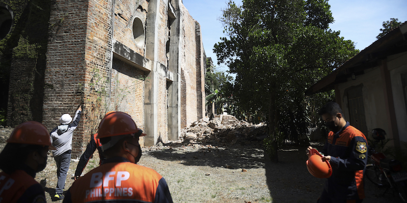 I vigili del fuoco ispezionano un edificio parzialmente crollato a causa del terremoto a Ilocos Norte, nel nord delle Filippine, 26 ottobre (AP Photo)