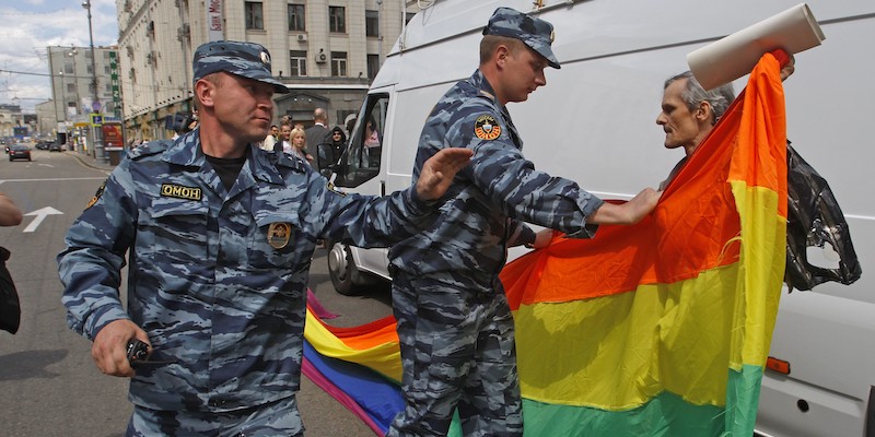 Due agenti della polizia russa arrestano una persona che partecipa a una sfilata del Pride a Mosca, in Russia, a maggio del 2012 (AP Photo/Mikhail Metzel, File)