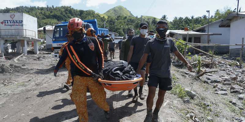 Alcuni soccorritori trasportano un corpo nella città di Datu Odin Sinsuat, provincia di Maguindanao, nel Sud delle Filippine (AP Photo)