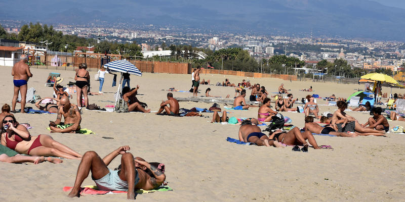 Persone in costume da bagno su una spiaggia di Catania, il 30 ottobre 2022 (ANSA/ORIETTA SCARDINO)