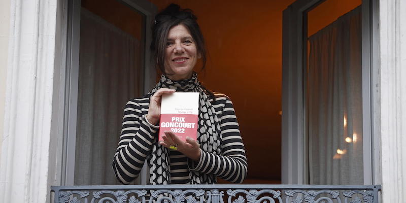 La scrittrice Brigitte Giraud affacciata alla finestra del ristorante Drouant di Parigi dopo aver vinto il premio Goncourt per il romanzo "Vivre vite", il 3 novembre 2022 (EPA/YOAN VALAT, ANSA)