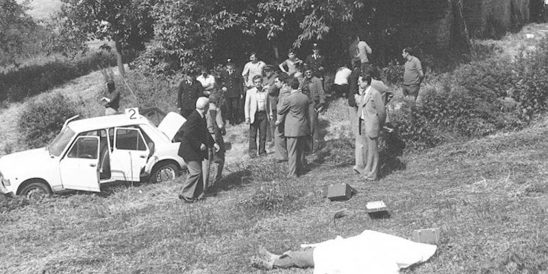 Gli inquirenti a cascina Spiotta, dopo la sparatoria del 5 giugno 1975. Sul prato, il corpo di Mara Cagol. (Ansa)