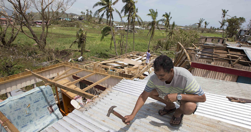 Un uomo ripara una casa danneggiata dal passaggio del ciclone Winston nel 2016 (Brett Phibbs/ New Zealand Herald via AP)