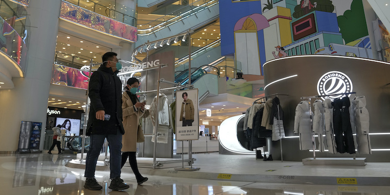 Persone che camminano in un centro commerciale da poco riaperto a Pechino, in Cina (AP Photo/Andy Wong)