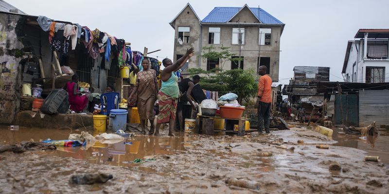 Alcune persone intente a pulire le strade dal fango a Kinshasa, nella Repubblica Democratica del Congo (AP Photo/Samy Ntumba Shambuyi)