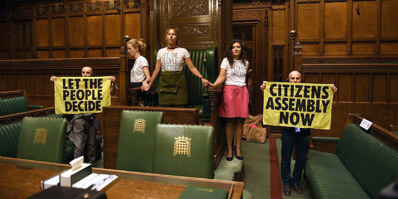 Un gruppo di attiviste di Extinction Rebellion incollate tra loro attorno al seggio dello speaker della Camera dei comuni