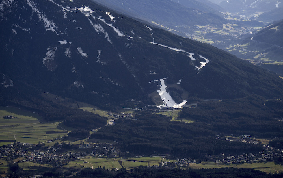 Piste da sci innevate in mezzo a boschi verdi sui fianchi del Patscherkofel, montagna vicina a Innsbruck, in Austria