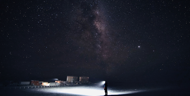 Una persona fuori dalla base Concordia, in Antartide, durante la notte polare; nel cielo la Via Lattea