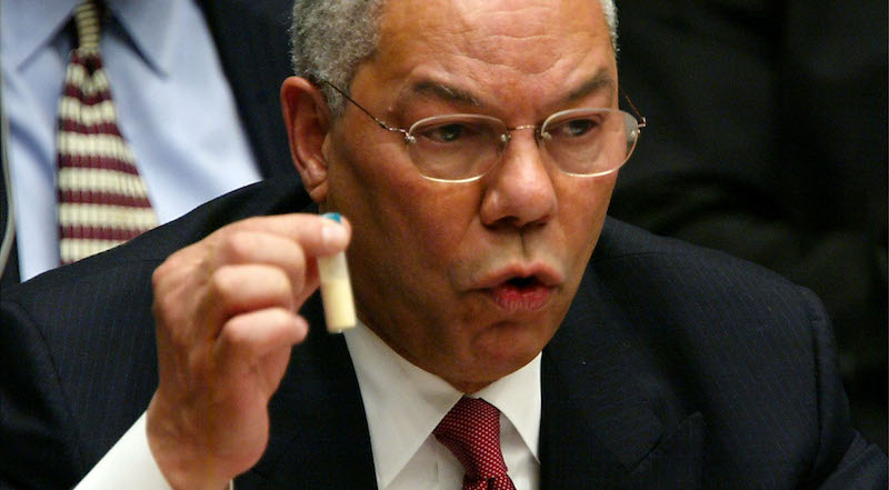 Colin Powell con una fialetta piena di polvere bianca in mano