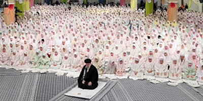 Ali Khamenei intento a pregare insieme a decine di ragazzine iraniane, dietro di lui