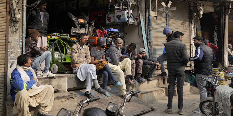 Commercianti e operai attendono il ritorno dell'energia elettrica durante un blackout a Lahore (AP Photo/K.M. Chaudary)