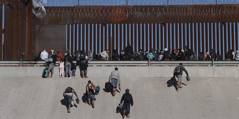 Migranti che si avvicinano al muro di confine tra Messico e Stati Uniti (AP Photo/Christian Chavez, File)