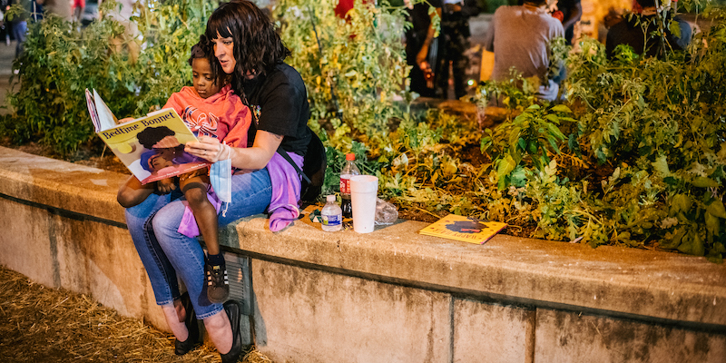 Una donna bianca legge un libro a una bambina nera, a Louisville, in Kentucky (Brandon Bell/Getty Images)