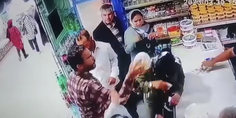 Un fermo immagine del video in cui l'uomo rovescia dello yogurt in testa alle due donne iraniane senza velo (dal canale YouTube del Telegraph)