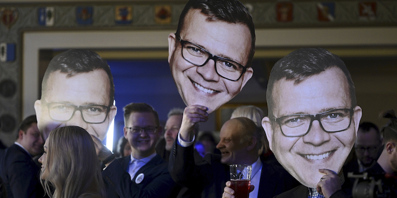 Sostenitori del Partito di Coalizione Nazionale con in mano cartonati del leader del partito, Petteri Orpo (Antti Aimo-Koivisto/Lehtikuva via AP)