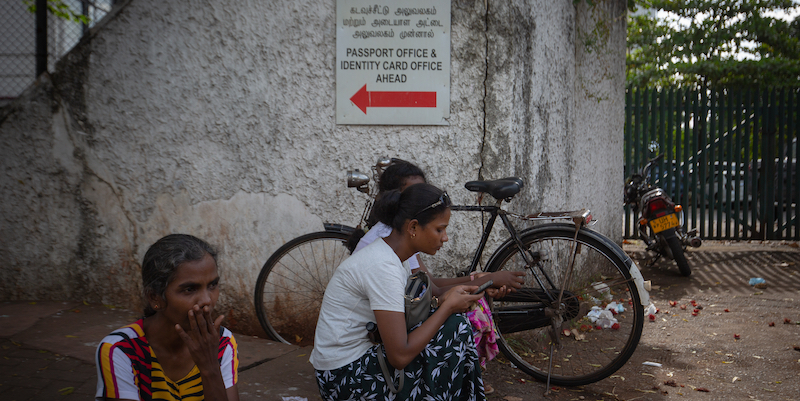 Alcune donne aspettano in strada il loro turno per presentare domanda per un nuovo passaporto all'esterno del Dipartimento Immigrazione ed Emigrazione. Colombo, Sri Lanka, 18 luglio 2022 (Foto Abhishek Chinnappa/Getty Images)