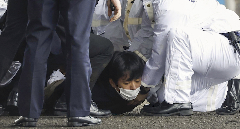 La persona che ha lanciato la bomba contro Kishida, immobilizzata e arrestata (Kyodo News via AP)