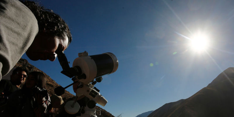 Una persona osserva il cielo con un telescopio prima dell'eclissi solare del 2 luglio del 2019 a Paiguano, in Cile
