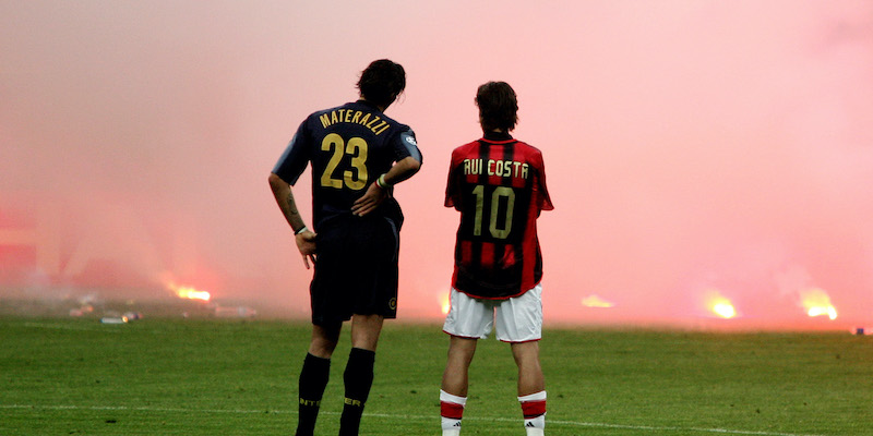 La famosa foto di Marco Materazzi e Rui Costa che guardano i fumogeni lanciati in campo nel derby di ritorno del 2005 (Marco Lussoso/LaPresse)
