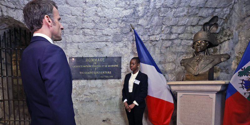 Emmanuel Macron di fronte a un busto di Toussaint Louverture (Christophe Petit Tesson, Pool via AP)