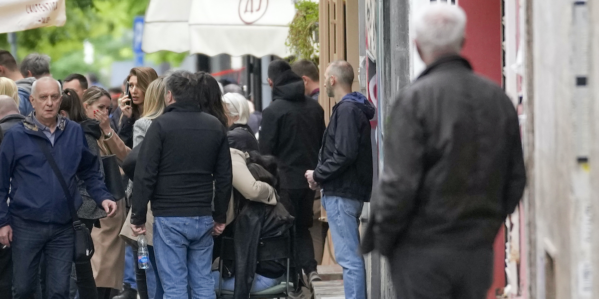 Diverse persone che si sono radunate davanti alla scuola Vladislav Ribnikar dopo la sparatoria (AP Photo/Darko Vojinovic)