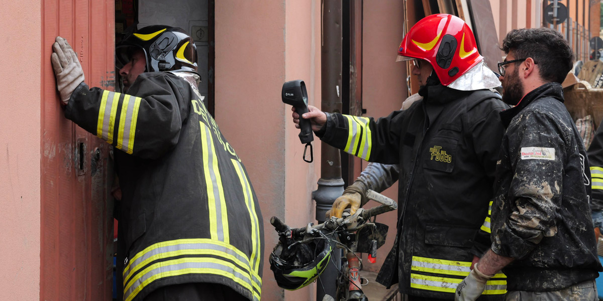 Vigili del fuoco controllano l'interno di un garage da cui esce del fumo, a Castel Bolognese (Valentina Lovato/Il Post)