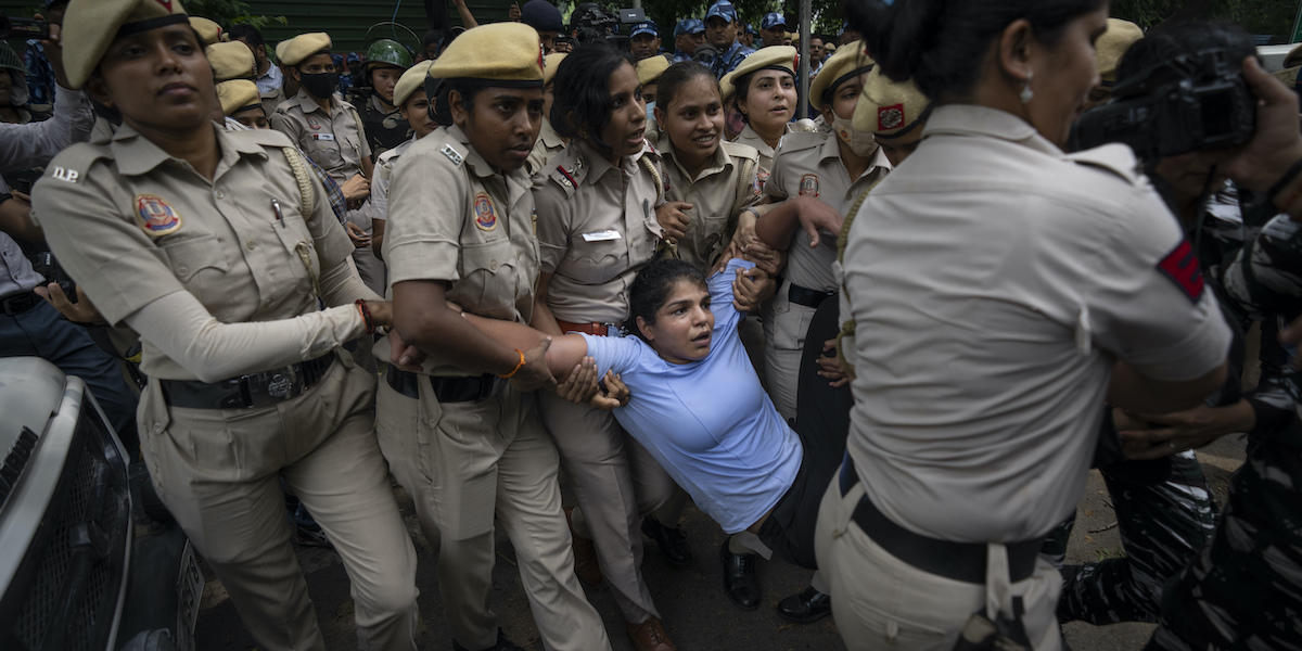 Davanti alla nuova sede del parlamento indiano a Nuova Delhi, Sakshi Malik, vincitrice della medaglia di bronzo nella lotta libera alle Olimpiadi del 2016, viene portata via dalla polizia (AP Photo/Altaf Qadri)