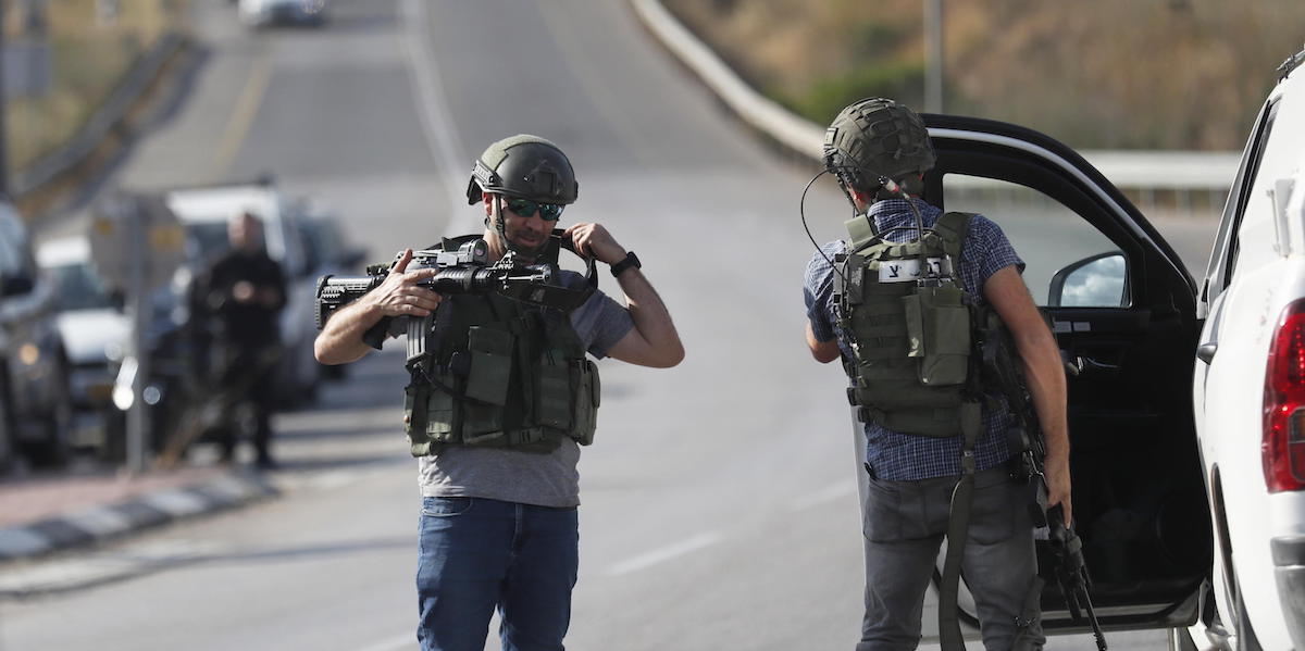 Due soldati israeliani in una strada fuori dall'insediamento di Eli, in Cisgiordania (EPA/ATEF SAFADI)