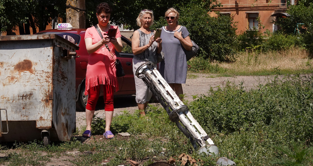 Dei residenti fotografano una bomba a grappolo russa caduta a Sloviansk, in Ucraina, nel giugno 2022 (Scott Olson/Getty Images)