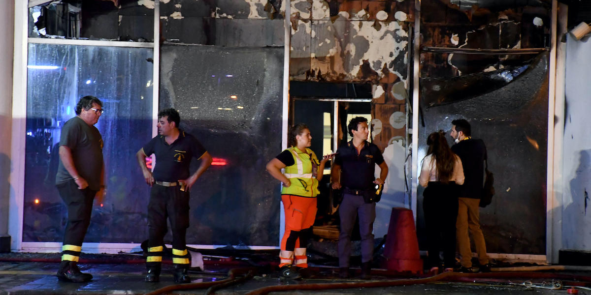 Vigili del fuoco davanti a una delle zone dell'aeroporto danneggiate dall'incendio (ANSA/ORIETTA SCARDINO)