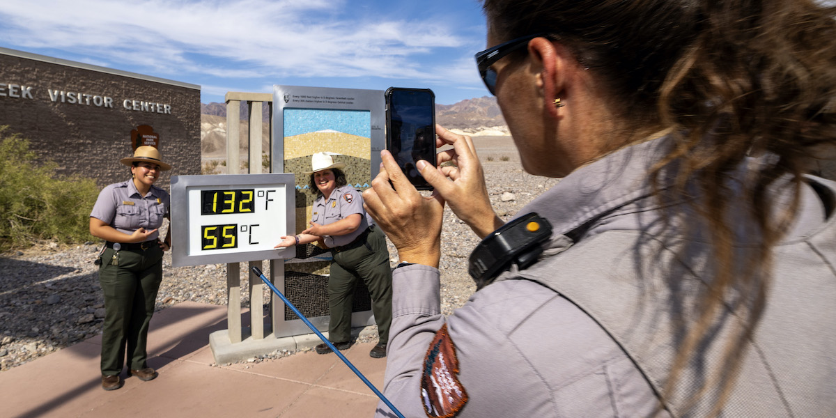 Due guardie forestali si fanno fotografare di fianco al termometro di Furnace Creek (David McNew/Getty Images)