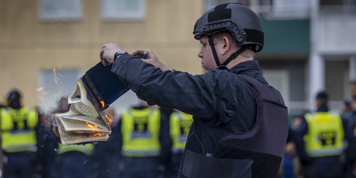 L’estremista di destra Rasmus Paludan mentre brucia una copia del Corano a Stoccolma, 14 maggio 2022 (Jonas Gratzer/Getty Images)