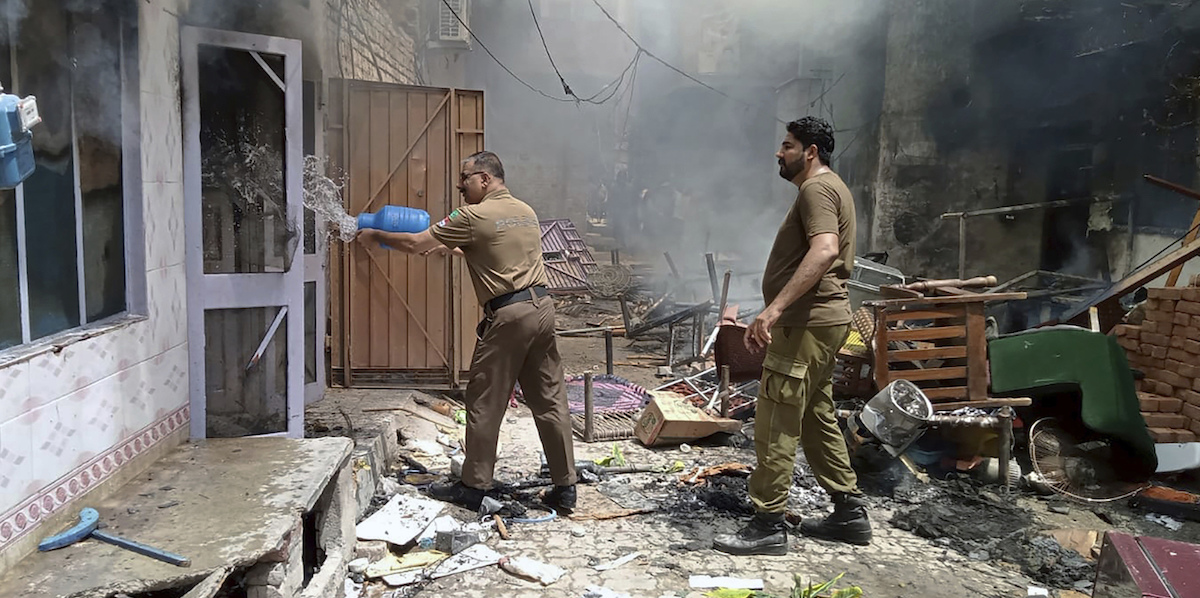 Soccorritori che cercano di spegnere l'incendio appiccato nelle chiese (District Police Office via AP)