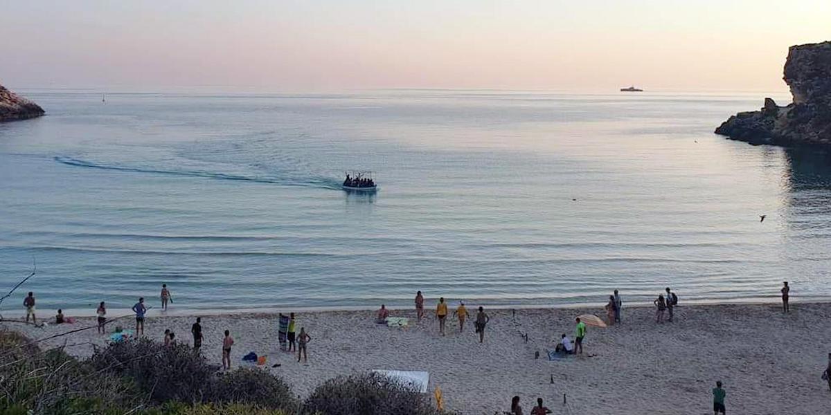 Una barca con 21 tunisini a bordo arriva sull'isola dei Conigli a Lampedusa tra i turisti sbigottiti, 14 settembre 2019 (ANSA/CONCETTA RIZZO)