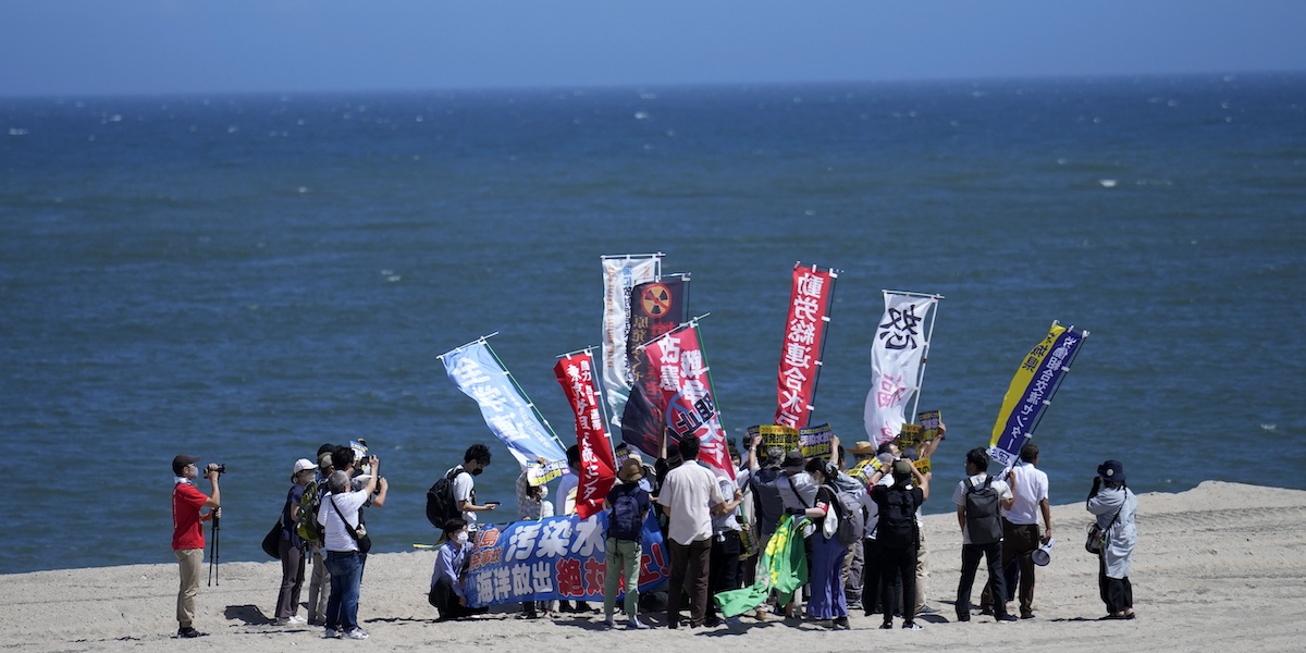 Una manifestazione di protesta contro la dispersione dell'acqua accumulata nell'ex centrale nucleare di Fukushima su una spiaggia poco lontana dall'impianto, a Namie, il 24 agosto 2023 (AP Photo/Eugene Hoshiko, LaPresse)