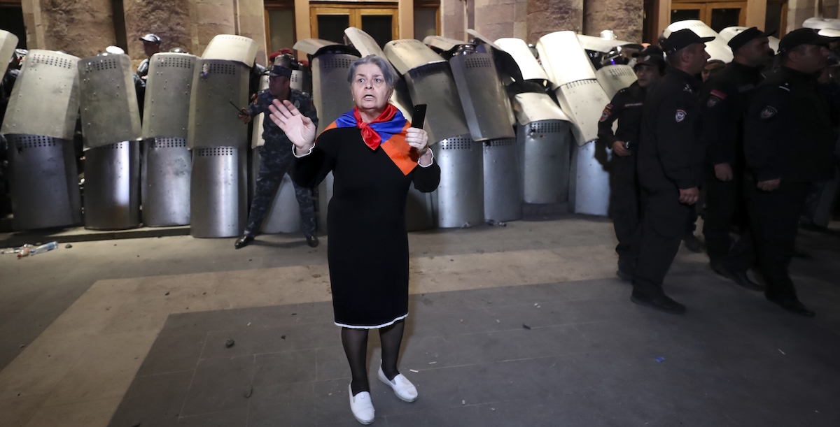 Una donna con una bandiera dell'Armenia al collo durante le proteste di mercoledì sera a Yerevan (Vahram Baghdasaryan/Photolure via AP)