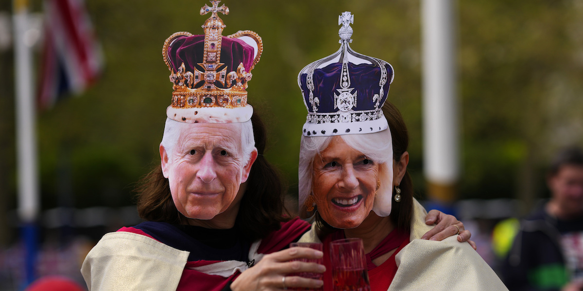 Due persone che indossano la maschera del re Carlo III e della regina consorte Camilla (AP Photo/Petr Josek )