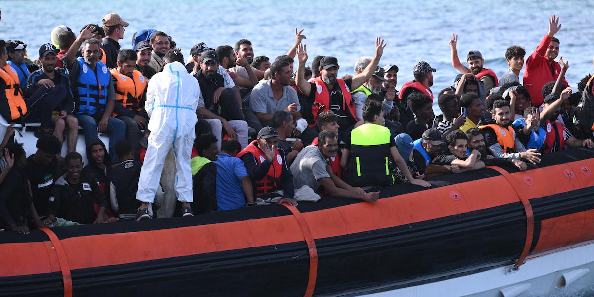 Migranti che arrivano nel porto di Lampedusa (ANSA/CIRO FUSCO)