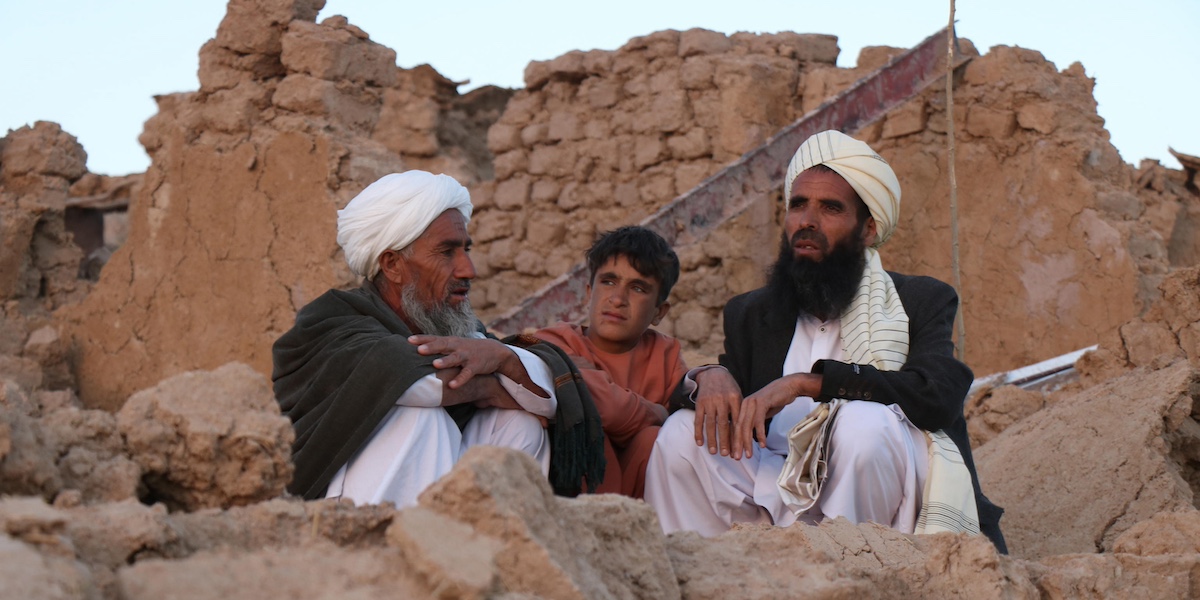Tre persone aspettano i soccorsi nella provincia di Herat, Afghanistan (EPA/STRINGER via ANSA)
