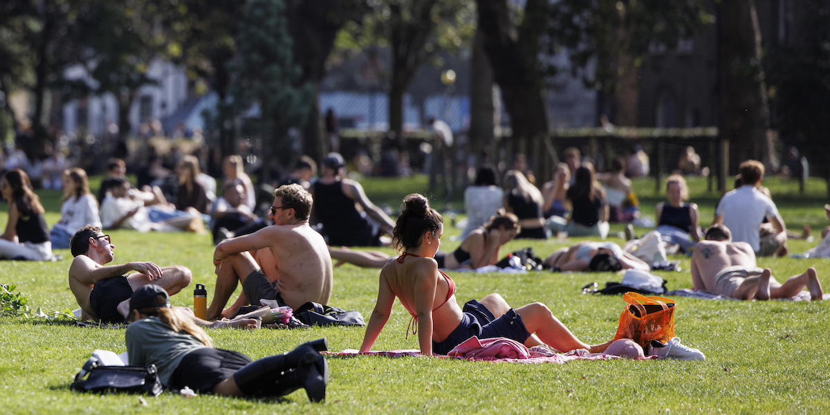 Persone stese al sole nel parco London Fields, a Londra, l'8 ottobre 2023 (EPA/TOLGA AKMEN, ANSA)