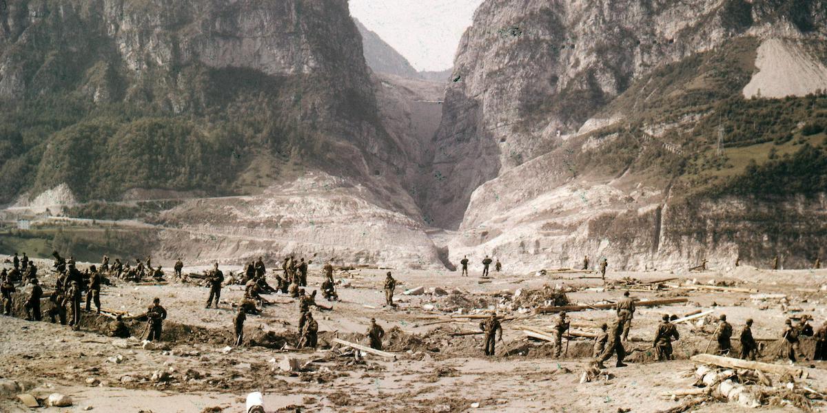 I soccorsi dopo il disastro e sullo sfondo la diga del Vajont (ANSA/OLDPIX)